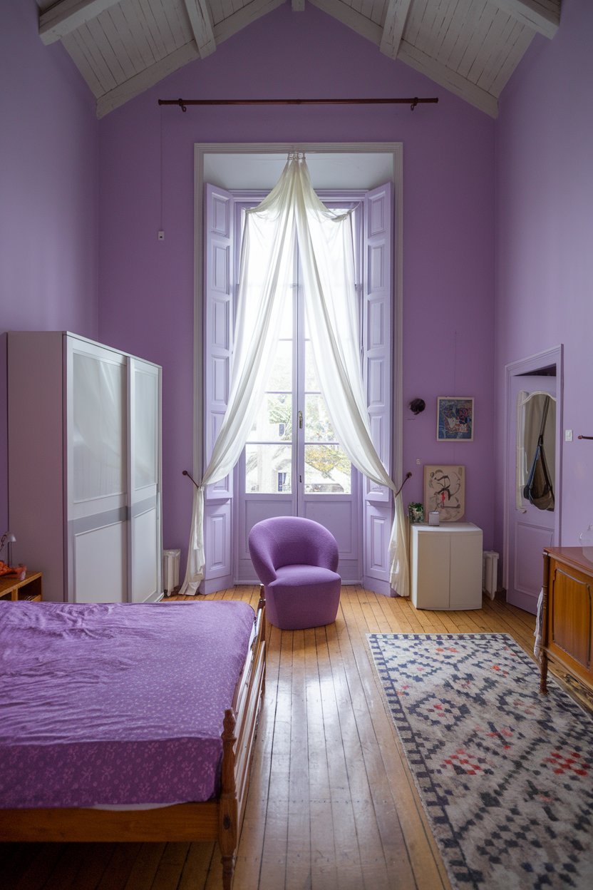a purple bedroom with a high ceiling. The room has a large window with a white curtain. There's a wooden bed with a purple bedsheet. There's a purple chair near the window. The floor is wooden. There's a white cabinet near the bed. The walls are painted purple.