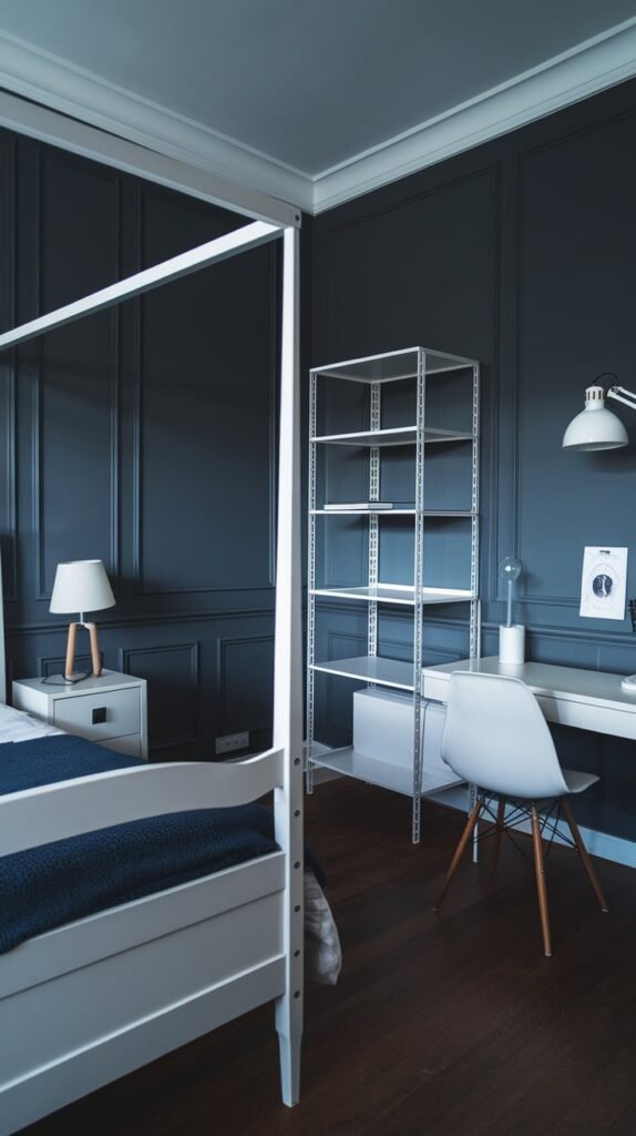 A modern minimalist bedroom with a dark blue wall, a white four-poster bed, a white desk, a white shelf, and dark hardwood floor.