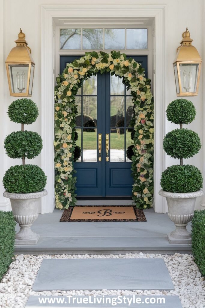 A sophisticated entrance combining a floral arch with symmetrically placed topiaries.