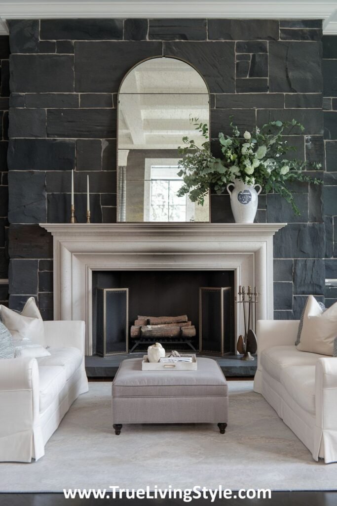 A dark stone fireplace with minimalist decor, highlighting the stone's texture.
