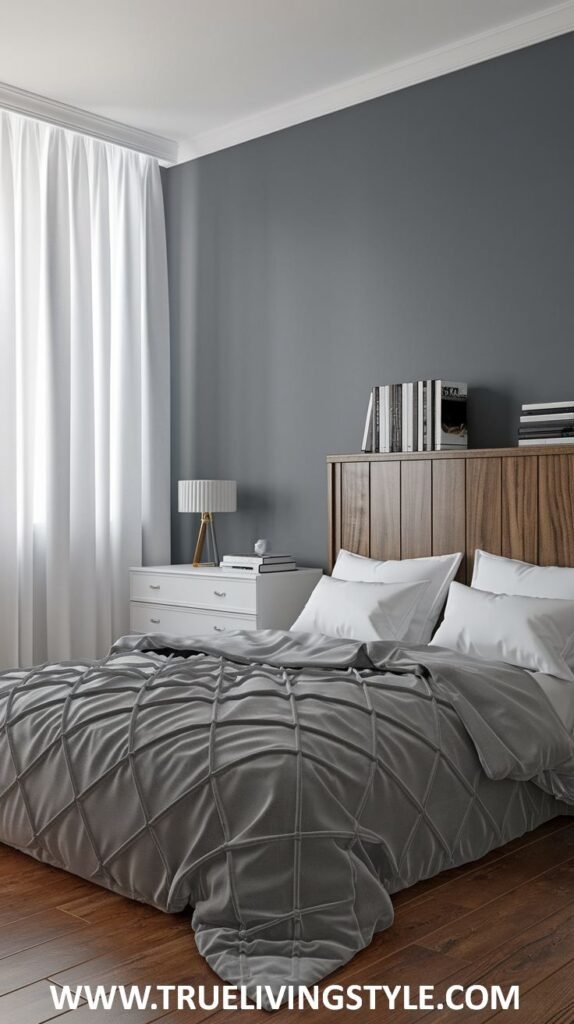 A modern and serene bedroom with deep gray walls and white trim. A wooden headboard bed with white and gray textured bedding is visible.