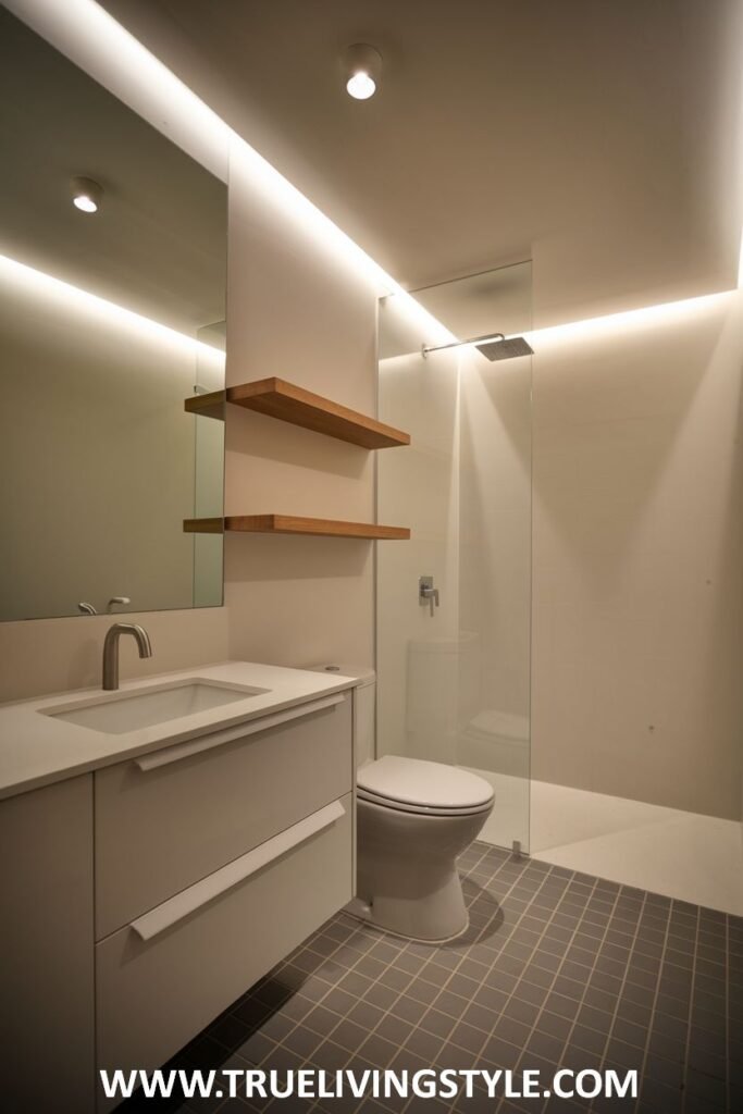 A sleek Minimalist Bathroom with recessed lighting and an integrated shower area behind a glass screen, complemented by a modern vanity.