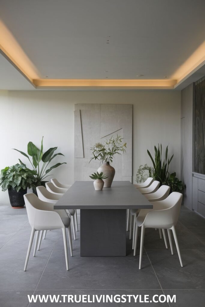 An industrial edge minimalist dining space with a gray table, simple white chairs, and large potted plants.