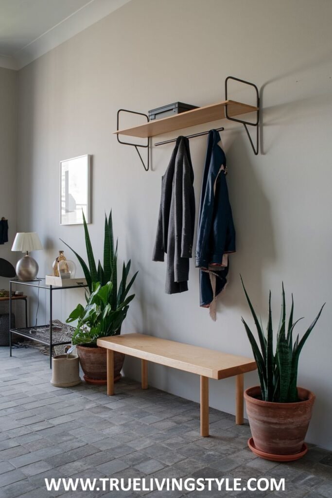 A hallway featuring a wooden bench, potted plants, and a wall-mounted shelf with coat hooks.