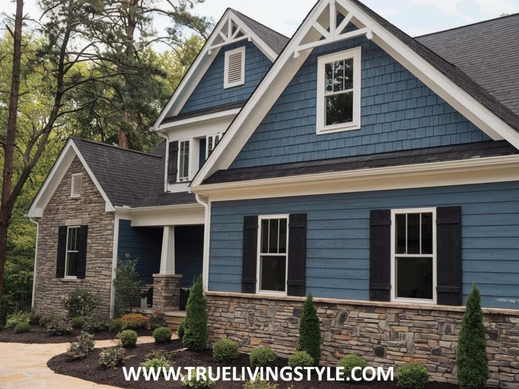 A two-story house with dual-tone blue siding, stone accents on the lower level, a dark shingle roof, and classic dormer windows.