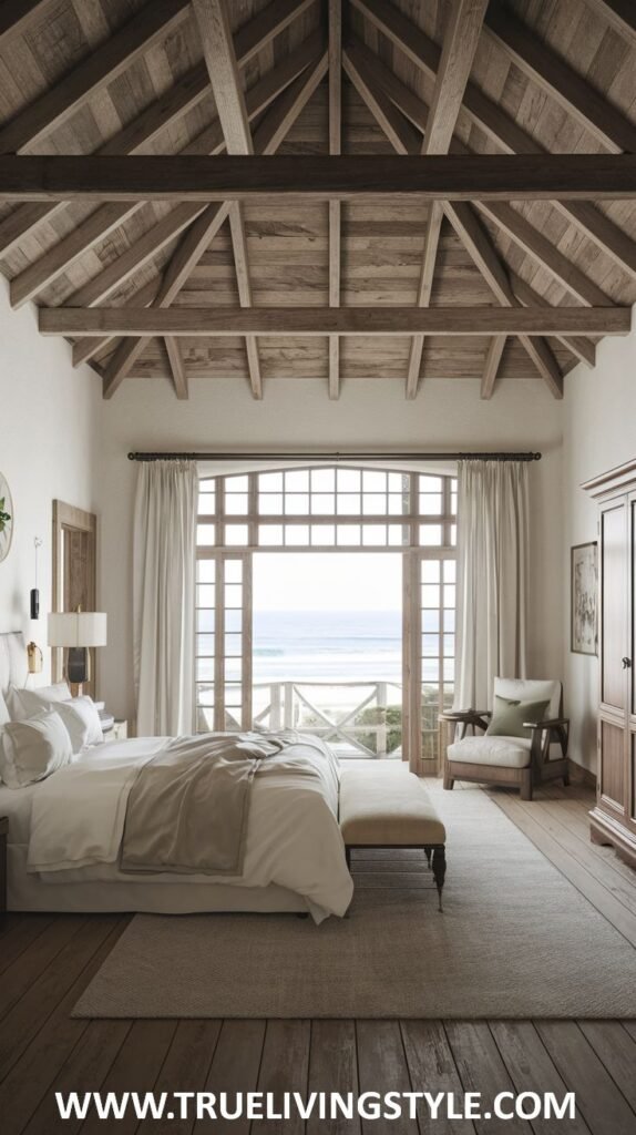 A rustic modern coastal bedroom combining exposed wooden beams with modern furnishings and a balcony providing access to coastal air and views.