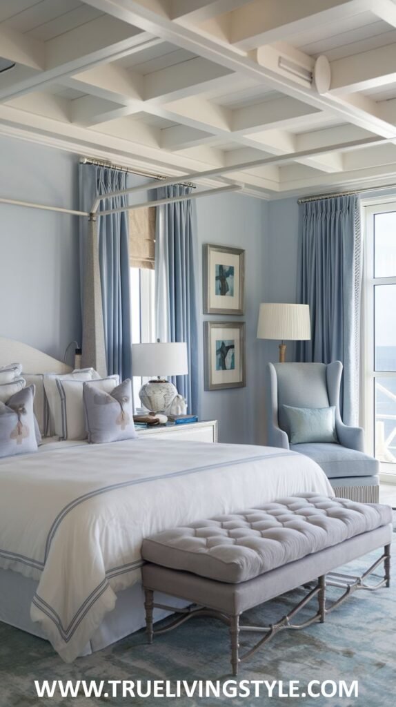 A soft blue modern coastal bedroom with pale blue walls, a canopy bed, large windows with an ocean outlook, and textured bedding.