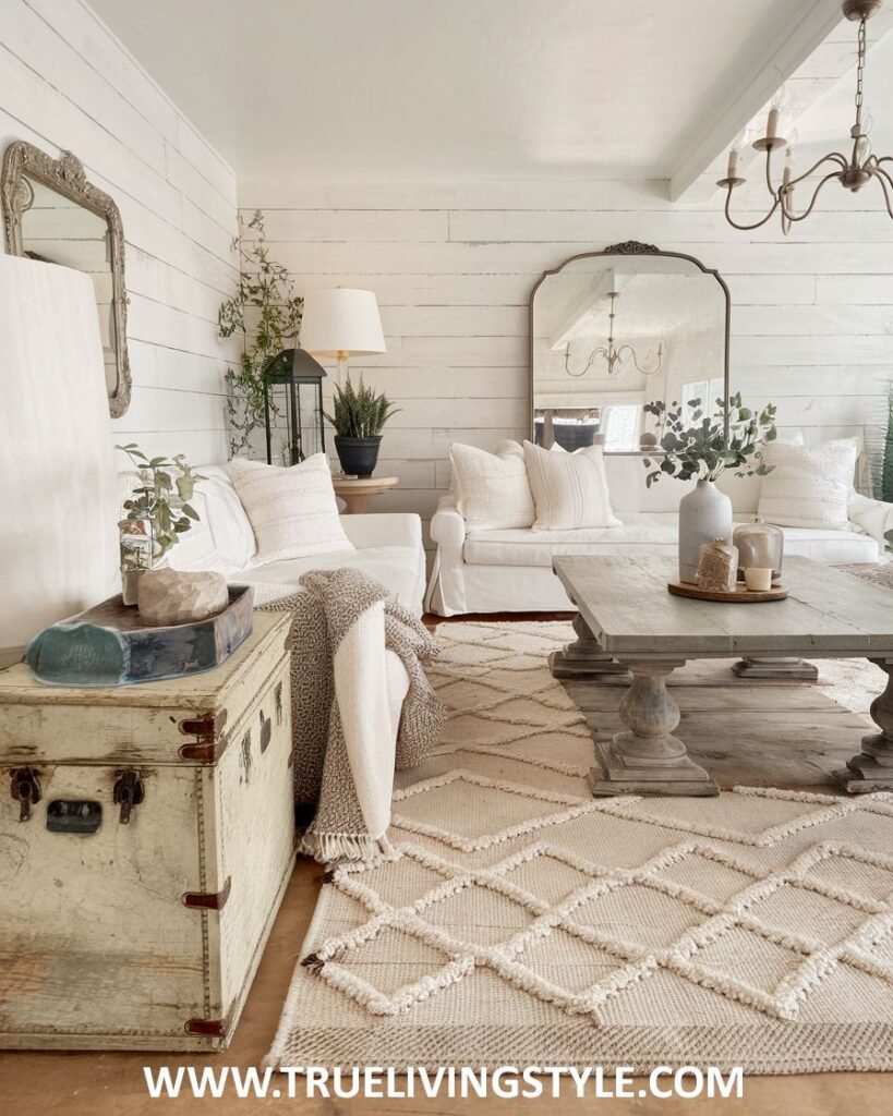 A farmhouse-style living room with vintage trunks and shiplap walls.