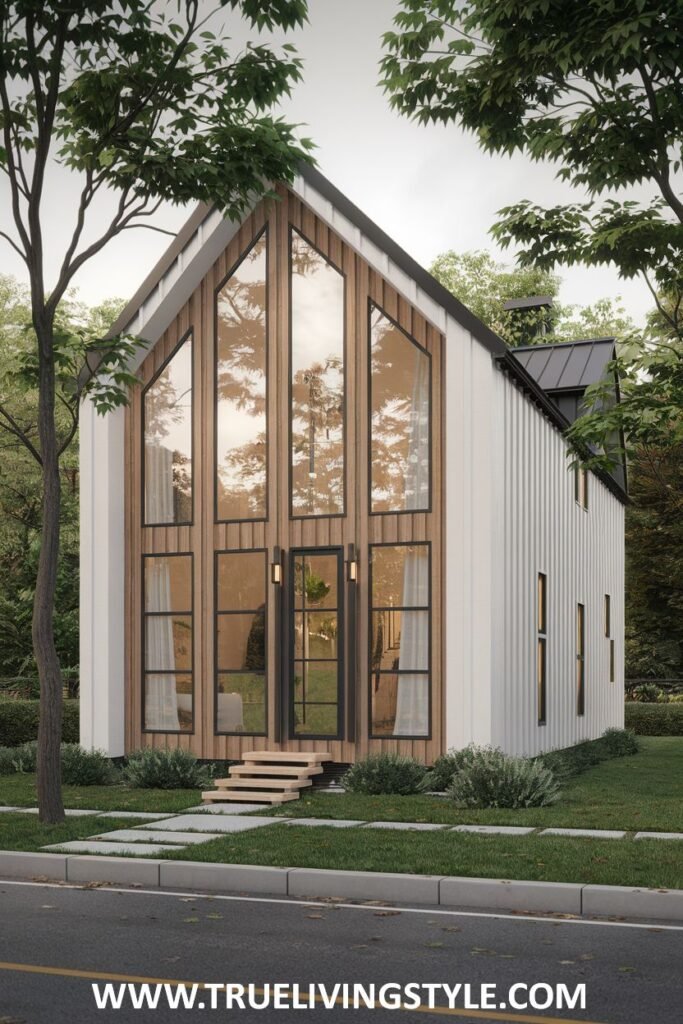 Modern exterior view of a narrow, gabled house with large front windows and white siding, located near a street and trees.