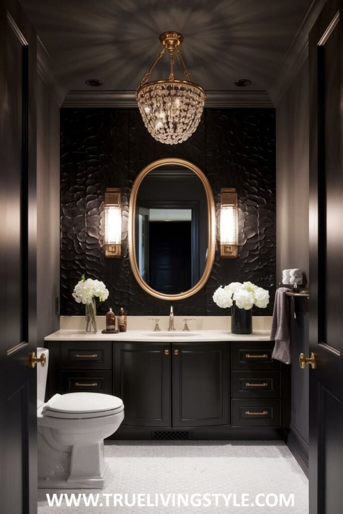 An elegant and dark luxury powder room with a textured black wall, a gold-framed oval mirror flanked by sconces, a white countertop on a black vanity, and a prominent crystal chandelier.