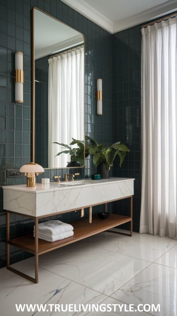A serene and stylish luxury powder room featuring dark teal tiled walls, a large rectangular mirror, a sleek marble countertop with a contemporary vessel sink and gold fixtures, and a wooden shelf providing storage.
