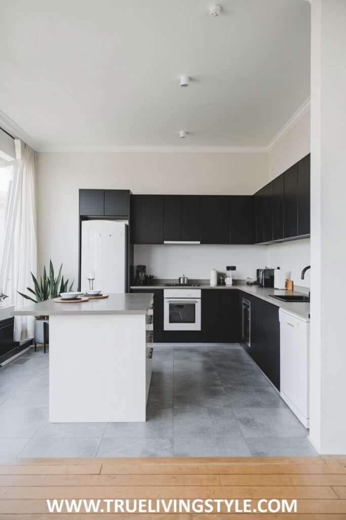 A two-toned kitchen with black and white cabinets and a white island.