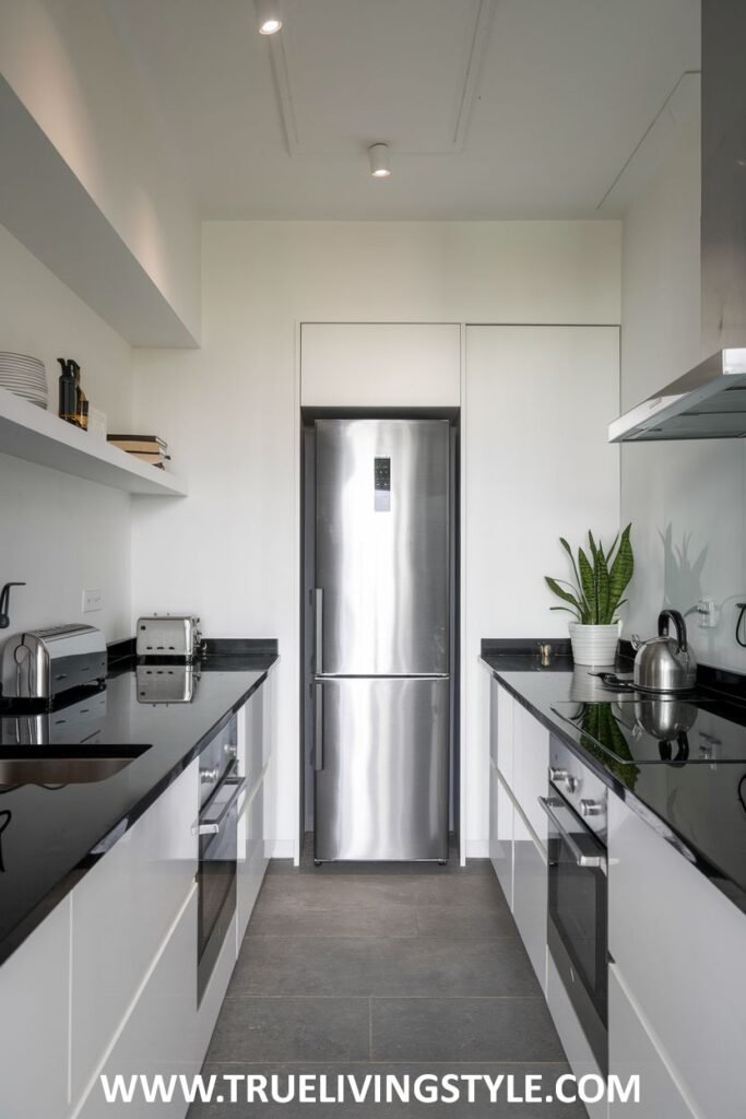 A narrow kitchen layout with appliances and cabinets along both walls.