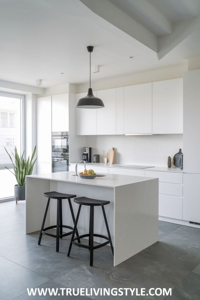 A kitchen island with black stools and a black pendant light.