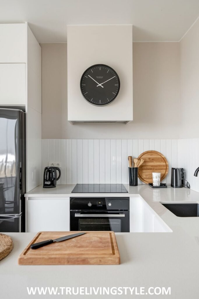 A kitchen featuring a black clock on the wall.