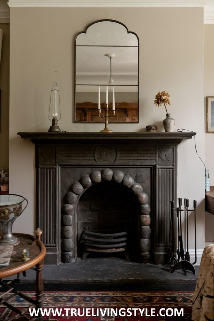 A simple yet elegant victorian fireplace made from cast iron featuring a characteristic arched opening with decorative molding and a mirror above.